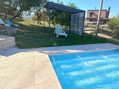 a chair sitting next to a swimming pool at Cabaña Punta Piedras in Villa Carlos Paz