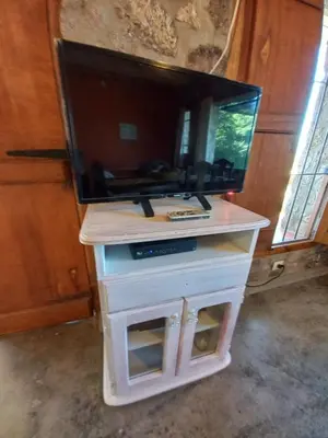 a tv on a stand with a fish aquarium on it at Cabaña Punta Piedras in Villa Carlos Paz