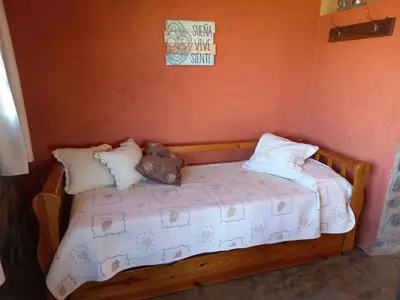 a wooden bed with pillows on it in a room at Cabaña Punta Piedras in Villa Carlos Paz