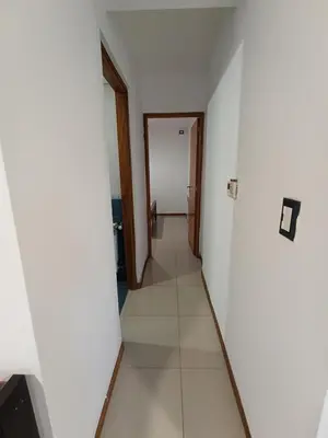an empty hallway with white walls and a door at Departamento Centrico San Jose II in Villa Carlos Paz