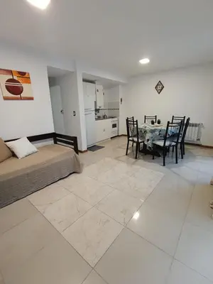 a living room with a bed and a table and chairs at Departamento Centrico San Jose II in Villa Carlos Paz