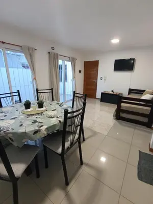 a dining room with a table and chairs and a couch at Departamento Centrico San Jose II in Villa Carlos Paz
