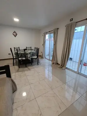 a living room with a table and chairs on a tile floor at Departamento Centrico San Jose II in Villa Carlos Paz