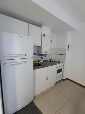 a kitchen with white cabinets and a white refrigerator at Departamento Centrico San Jose II in Villa Carlos Paz