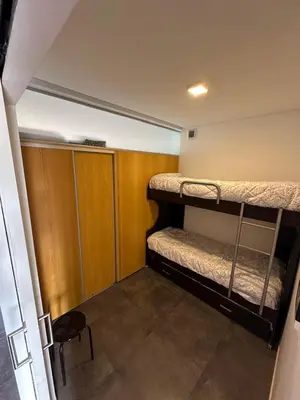 a small room with two bunk beds and a chair at Puerto del Águila Departamento con vista al lago- The View Luxuary Aparts in Potrero de Garay