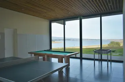 two ping pong tables in a room with large windows at Puerto del Águila Departamento con vista al lago- The View Luxuary Aparts in Potrero de Garay