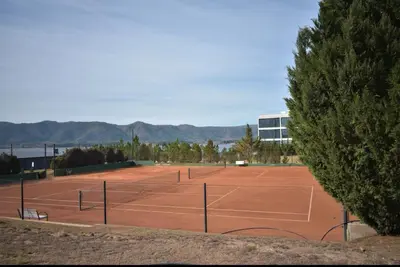 a tennis court with two tennis rackets on it at Puerto del Águila Departamento con vista al lago- The View Luxuary Aparts in Potrero de Garay