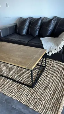 a black couch with a coffee table in a living room at Puerto del Águila Departamento con vista al lago- The View Luxuary Aparts in Potrero de Garay