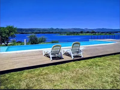 two chairs sitting on a deck next to a swimming pool at Puerto del Águila Departamento con vista al lago- The View Luxuary Aparts in Potrero de Garay