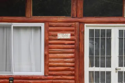 two windows on the front of a wooden house at La casita de la montaña in El Parador