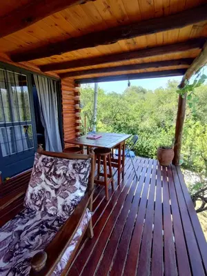 a porch with a table and a bench on a deck at La casita de la montaña in El Parador