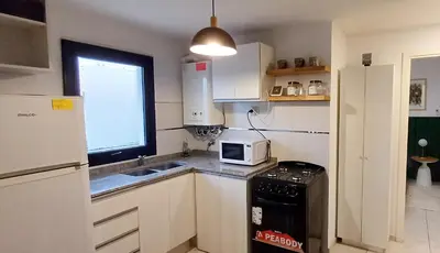 a small kitchen with a sink and a microwave at Departamento alquiler temporal Barrio General Paz in Cordoba