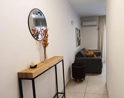 a living room with a table and a mirror at Departamento alquiler temporal Barrio General Paz in Cordoba