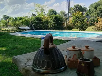 a tea kettle sitting on a table near a swimming pool at Cabaña en los solares in Villa Ciudad Parque