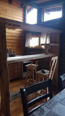 a kitchen with a table and chairs in a cabin at Cabaña en los solares in Villa Ciudad Parque