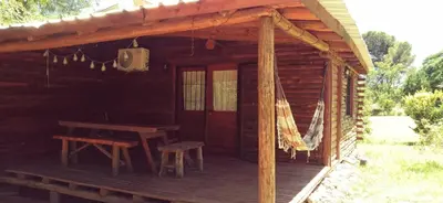a porch of a log cabin with a picnic table at Cabaña en los solares in Villa Ciudad Parque
