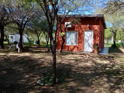 a small red house in a park with trees at Respira Alegría in Carpintería