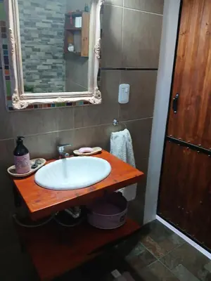 a bathroom with a white sink on a wooden counter at Respira Alegría in Carpintería