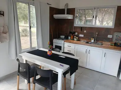a kitchen with a table and chairs and a sink at Respira Alegría in Carpintería
