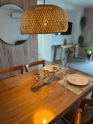 a wooden table with plates and glasses and a lamp at A estrenar!! Nordic Chic in Cordoba