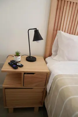 a bedside table with a lamp and a nightstand with a bed at A estrenar!! Nordic Chic in Cordoba