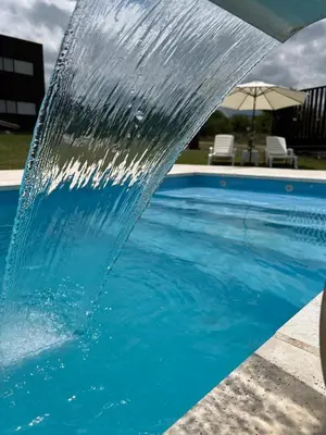 a pool with water spraying into the air at Chalet en Potrero de Garay in La Estancia