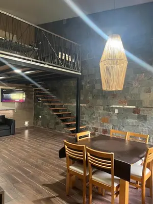 a dining room with a table and chairs and a staircase at Chalet en Potrero de Garay in La Estancia