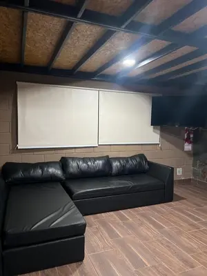 a black leather couch in a room with a whiteboard at Chalet en Potrero de Garay in La Estancia