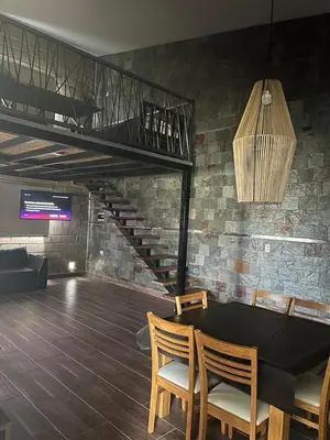 a dining room with a table and chairs and a staircase at Chalet en Potrero de Garay in La Estancia