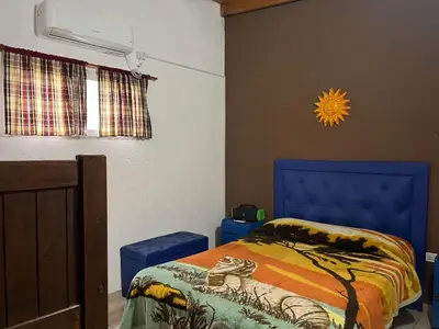 a bedroom with a bed with a blue head board at COMPLEJO AyH in Malagueño