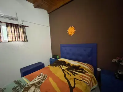 a bedroom with a bed with a blue head board at COMPLEJO AyH in Malagueño