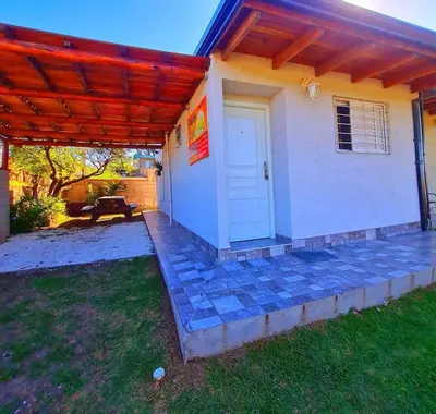 a white house with awning and a patio at COMPLEJO AyH in Malagueño