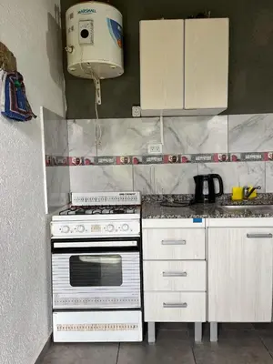 a kitchen with a stove and a toaster at COMPLEJO AyH in Malagueño