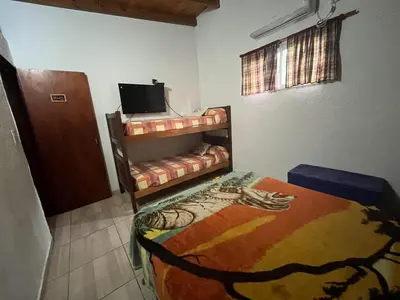 a room with two bunk beds and a television at COMPLEJO AyH in Malagueño