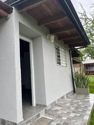 a small white house with a door and a porch at COMPLEJO AyH in Malagueño