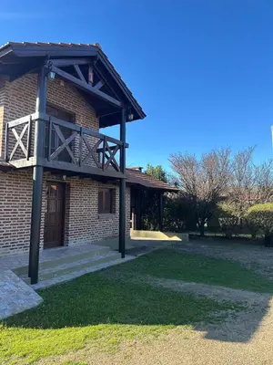 a building with a balcony on the side of it at Cabañas Costa Alta in Mina Clavero