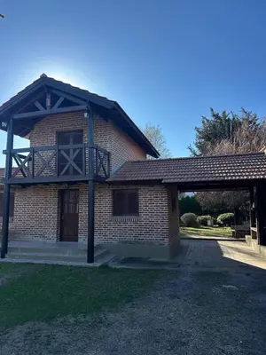 a brick building with a balcony on top of it at Cabañas Costa Alta in Mina Clavero