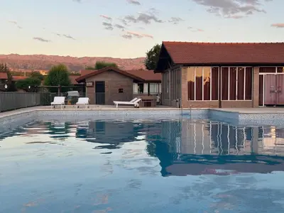 a swimming pool in front of a house at Cabañas Costa Alta in Mina Clavero