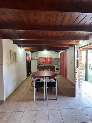 a kitchen and dining room with a table and chairs at Cabañas Costa Alta in Mina Clavero