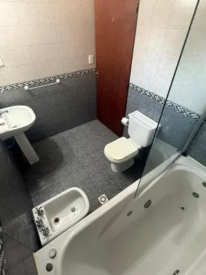a bathroom with a toilet and a tub and a sink at Cabañas Costa Alta in Mina Clavero