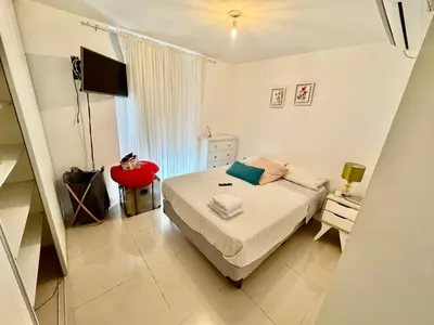 a small white bedroom with a bed and a window at Buena vista in Cordoba