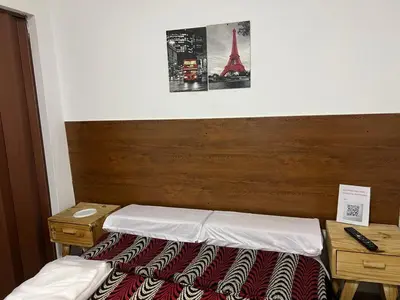 a bedroom with a bed with a wooden headboard and the eiffel tower at Hospedaje Malvinas in Alta Gracia