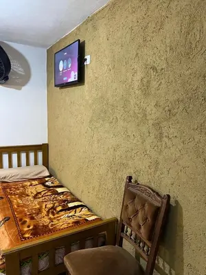 a bedroom with a bed and a tv on the wall at Hospedaje Malvinas in Alta Gracia