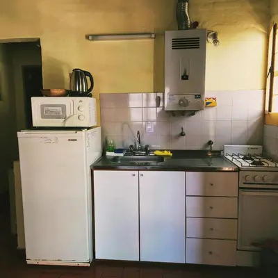 a kitchen with a white refrigerator and a microwave at Los Zarzos in Mina Clavero