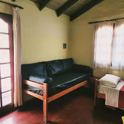 a couch in a room with a bed and windows at Los Zarzos in Mina Clavero