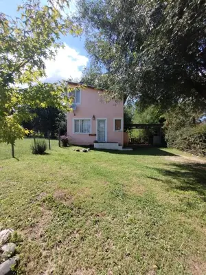 a pink house with a large yard at Cabañas Megustayacanto in Villa Yacanto