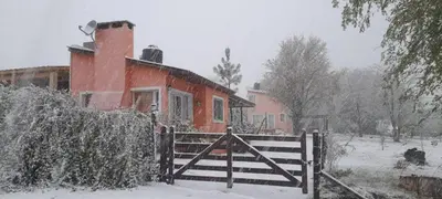 a house with a gate in the snow at Cabañas Megustayacanto in Villa Yacanto