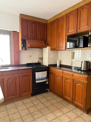 a kitchen with wooden cabinets and a black stove top oven at ituzaingo house in Cordoba