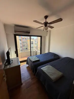 a bedroom with two beds and a ceiling fan at ituzaingo house in Cordoba
