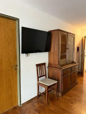 a room with a chair and a tv on a wall at ituzaingo house in Cordoba